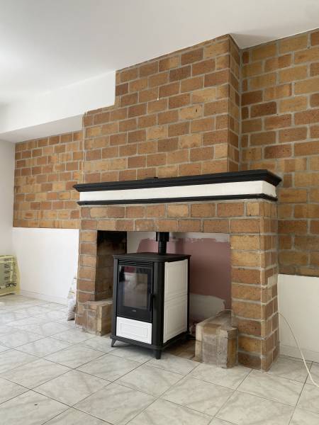 Poêle à granulés bas Miss de Klover dans une cheminée traditionnelle à Mas Thibert